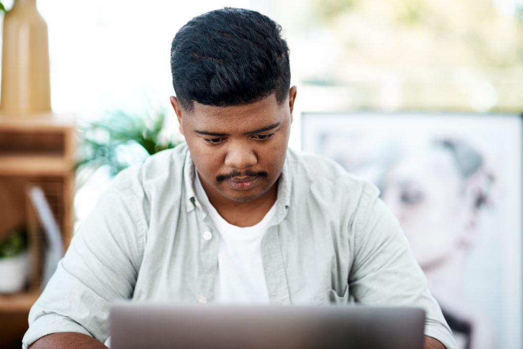 Young man using a laptop in a modern office