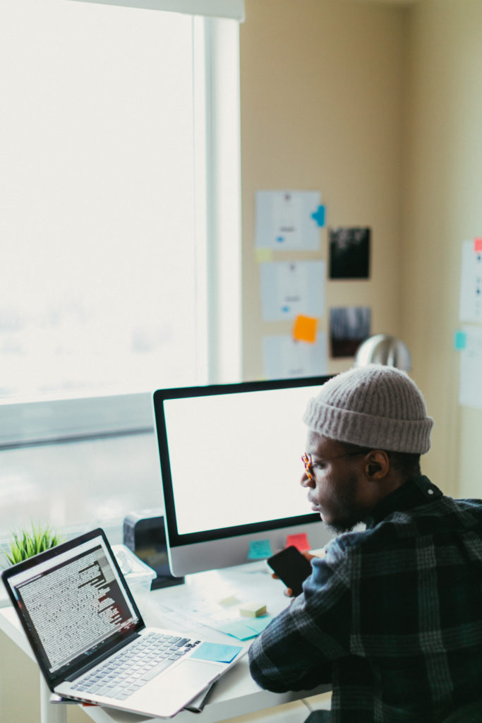 African American man in his 20s working at his desk on his computer