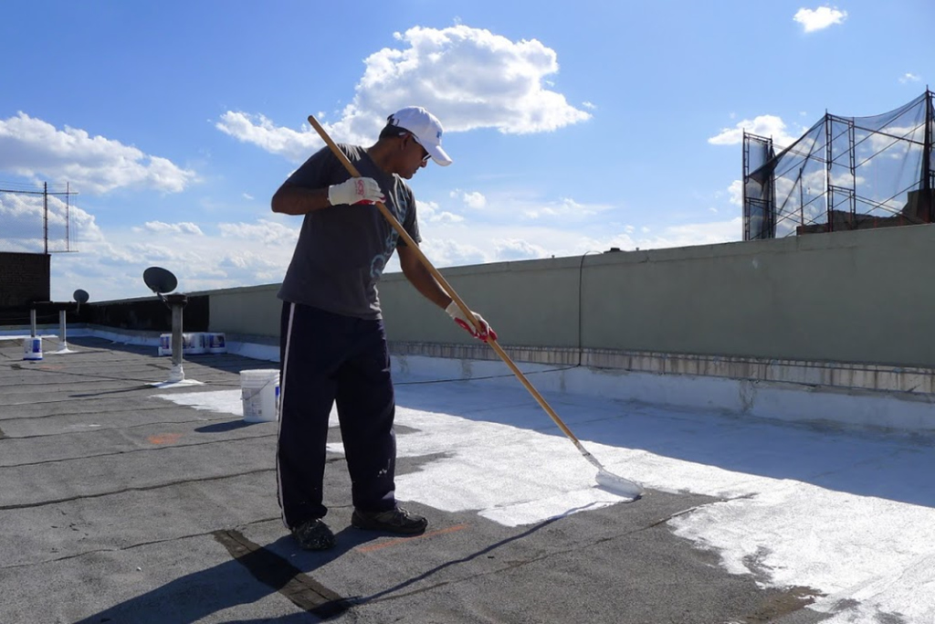 Male painting a roof white