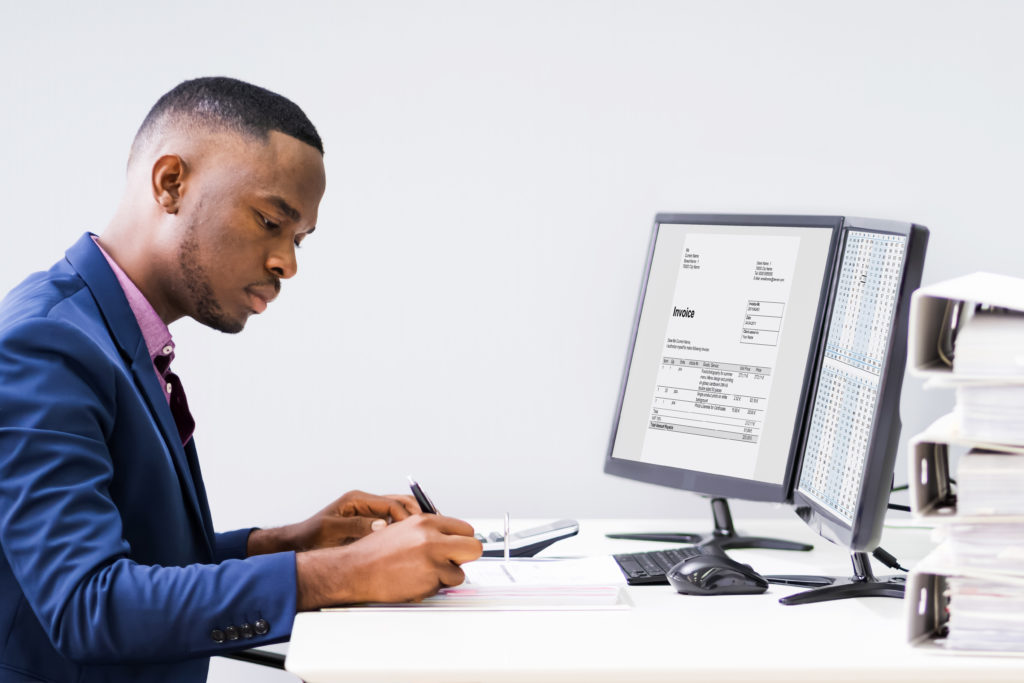 Young African Businessman Calculating Bills Using Calculator